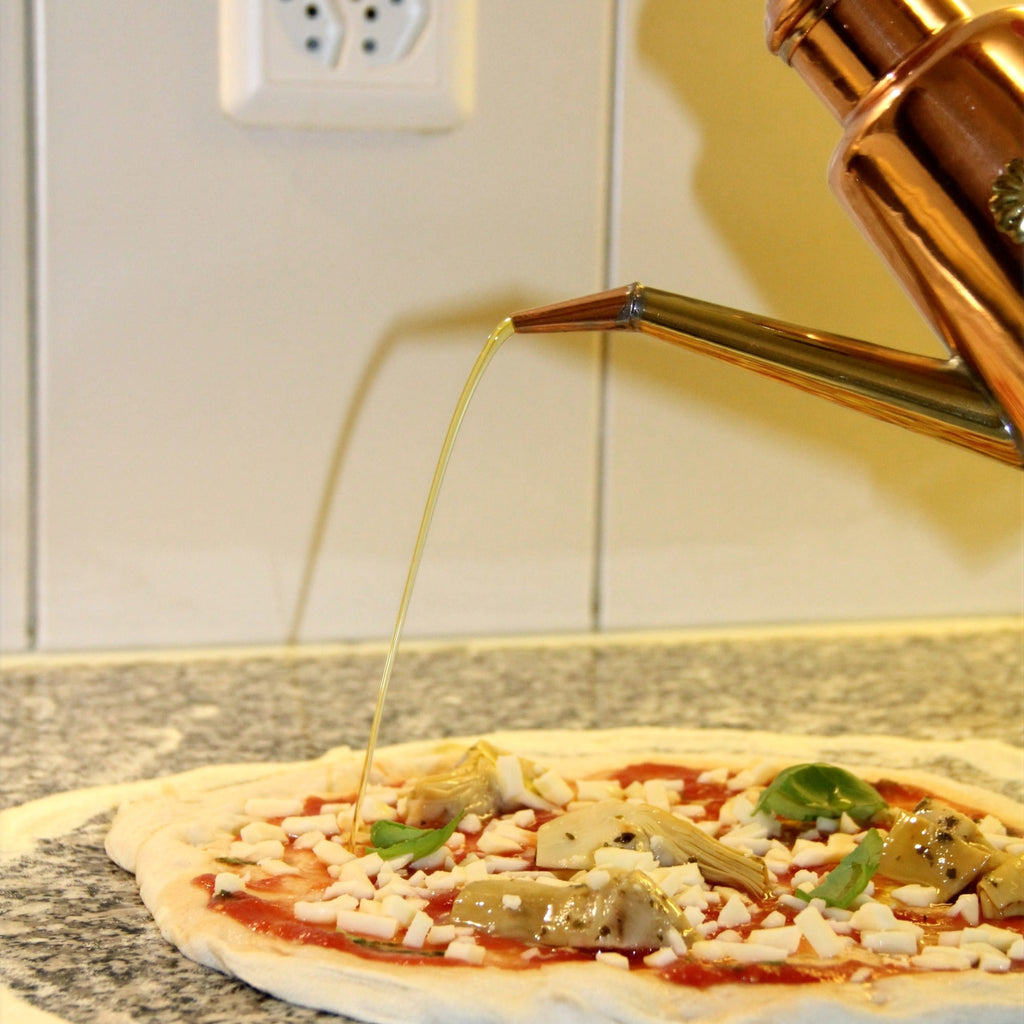 Oliera träufelt öl auf Pizza