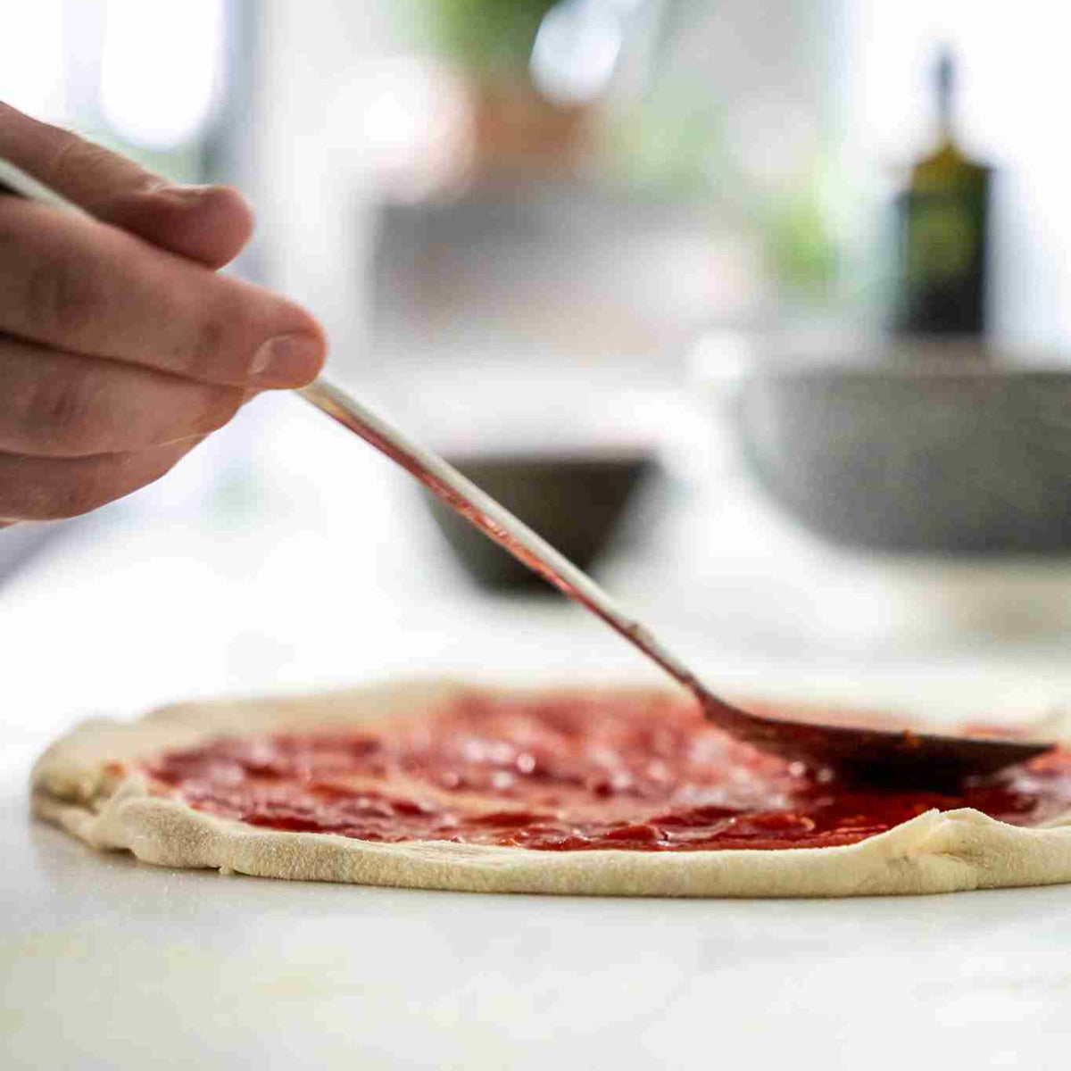 Pizza Saucenlöffel verteilt Tomatensauce