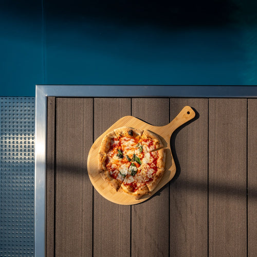 Bambus Pizzabrett mit Pizza am Pool